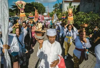  ?? JUNI KRISWANTO/GETTY-AFP ?? Hindu devotees prepare to take part in a Melasti ceremony prayer Sunday at the Segara temple in the city of Surabaya in Indonesia’s East Java province. Melasti is a purificati­on festival held several days before Nyepi, the day of silence, when the Hindu faithful are not allowed to work, travel or take part in any indulgence.