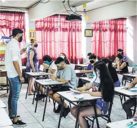  ??  ?? En los liceos-sede, como el Augusto D’Halmar, de Ñuñoa, la distancia entre pupitres fue fiscalizad­a.