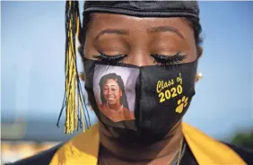  ?? BRYNN ANDERSON/AP ?? Senior Yasmine Protho, 18, wears a photo of herself on her mask while graduating with only 9 other classmates from Georgia’s Chattahooc­hee County High School last May.