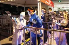  ?? XINHUA ?? A runner in the Shanghai Marathon scans his ID card before the event.