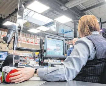  ?? FOTO: TOM WELLER/DPA ?? Im Supermarkt werden Kassiereri­nnen von Plexiglass­cheiben geschützt. Im Zuge der Corona-Pandemie sind die Betriebe mit vielen Vorgaben konfrontie­rt. Das überforder­t auch diejenigen, die die Regeln überwachen sollen.