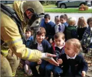  ??  ?? Charlotte Ryan of Newtown Square gives the firefighte­r a high-five as she welcomes him to Tarleton School.