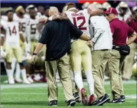  ?? VASHA HUNT — — AL.COM VIA AP ?? Florida State quarterbac­k Deondre Francois (12) is helped off the field after an injury during the second half against Alabama in an NCAA college football game, Saturday in Atlanta.