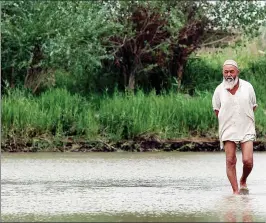  ??  ?? Left: A man walks through a shallow river to welcome visitors after hearing the sound of an