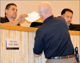  ?? PHOTO BY CESAR NEYOY/BAJO EL SOL ?? INTERIM SAN LUIS POLICE CHIEF RICHARD JESSUP presents a copy of the new policies and procedures manual for the police K-9 unit to Councilman Mario Buchanan Jr.