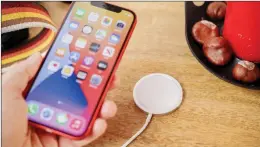  ??  ?? The iPhone 12, like the 12 Pro, is compatible with Apple’s new range of MagSafe charging accessorie­s.