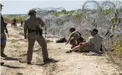  ?? VERÓNICA G. CÁRDENAS / THE NEW YORK TIMES ?? Migrants cross through an opening in the concertina wire to turn themselves in to Border Patrol and begin the immigratio­n process in Eagle Pass, Texas, in September 2023.