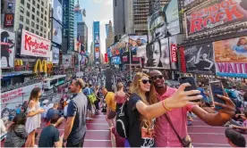  ??  ?? Self-preservati­on … tourists taking selfies in Times Square, New York. Photograph: Richard Green/Alamy