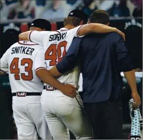  ?? JOHN BAZEMORE — THE ASSOCIATED PRESS ?? Atlanta Braves starting pitcher Mike Soroka (40) is helped off the field by manager Brian Snitker and a trainer after being injured in the third inning of Monday’s game against the New York Mets.