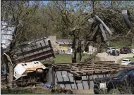  ?? (AP/The Topeka Capital-Journal/Evert Nelson) ?? Metal sidings are thrown up in trees on Ethan Steenbach’s property Tuesday morning in Overbrook, Kan., following a tornado that hit the area.