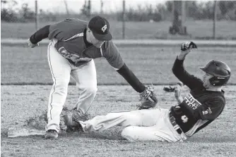  ?? SALTWIRE NETWORK FILE PHOTO ?? In this Sept. 22, 2019 file photo, Daniel Dalton of Kelly’s Pub Molson Bulldogs is tagged out by 3Cheers Bud Light Dodgers second baseman Kyle Ezekiel during a St. John’s Molson senior men’s playoff game at Lions Park. With guidelines related to COVID-19 for sports in the province finalized, the St. John’s softball league is set to start its 2020 season this week.