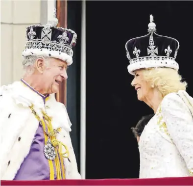  ?? LEON NEAL / POOL ?? Carlos III y Camilla, sonrientes con sus respectiva­s coronas, en el balcón del palacio de Buckingham.