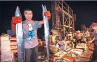  ?? WENG YEJUN / FOR CHINA DAILY ?? A fisherman shows newly harvested hairtail fish at Yazhou port in Sanya, Hainan province, early on Saturday. The port is welcoming the return of the first fully loaded fishing boats after the annual ban was lifted on Wednesday.