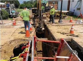  ?? ED RICHTER / STAFF ?? Lebanon Public Works crews work in extremely hot weather Wednesday as they install a sanitary sewer line for a new public restroom on Mechanic Street.