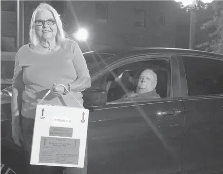  ?? LUIS SANTANA/TAMPA BAY TIMES ?? Marie Woody and her husband, Jerry, with a cooler containing a cornea specimen outside of the Lions Eye Institute in Tampa, Florida. They have driven across Florida to deliver thousands of donated corneas.