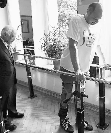  ?? Courtes y of BBC ?? Bulgarian patient Darek Fidyka, right, is walking with the assistance of parallel bars and leg braces.