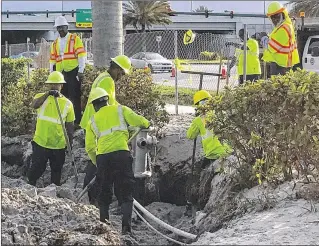  ?? TONY DORIS / THE PALM BEACH POST ?? Workers in the Best Buy parking lot on Palm Beach Lakes Boulevard work to repair a water main break that shut off service, forcing closings of Palm Beach Outlets’ food court, Whole Food Market and several restaurant­s Thursday. Mall shops did not have...