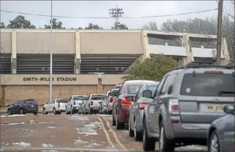  ?? Eric Shelton/The Clarion-Ledger via AP ?? A line of cars wraps around Smith-Wills Stadium on Friday in Jackson, Miss., as residents wait for bottled water. Most of the city had no running water, and the mayor said the water mains were not built to handle the freezing weather from the recent multiple storms.