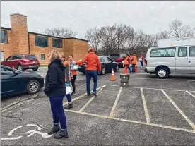  ?? PROVIDED ?? Area school parents by the thousands are making a daily stop at local schools to pick up free meals their children would normally receive if schools were in session. School districts in Butler and Warren counties saw officials scramble to give out food to students who need it. Teachers, staff and volunteers at Kings Local Schools hand out meals to students’ families on Friday.