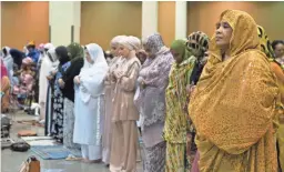  ??  ?? Women pray at an Eid celebratio­n Tuesday.