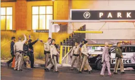  ?? L.E. Baskow Las Vegas Review-Journal @Left_Eye_Images ?? Metropolit­an Police Department officers move to a Fashion Show mall entrance after Tuesday’s shooting.