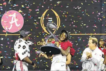  ?? Jeffrey McWhorter Associated Press ?? JAMESON WILLIAMS holds the trophy next to Nick Saban, right, who will go for a seventh title at Alabama.