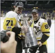  ?? MARK HUMPHREY — THE ASSOCIATED PRESS ?? Pittsburgh Penguins’ Evgeni Malkin (71), of Russia, and Sidney Crosby (87) pose for a photo with the Stanley Cup after defeating the Nashville Predators 2-0 in Game 6 of the NHL hockey Stanley Cup Final, Sunday in Nashville, Tenn.