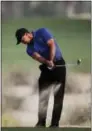  ?? KAMRAN JEBREILI — THE ASSOCIATED PRESS ?? Tiger Woods plays from the bunker on the 10th hole during the first round of the Dubai Desert Classic on Thursday. Woods withdrew Friday with what his agent said was back spasms.