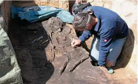  ?? FOTO: ANDREAS BAYER ?? Grabungsle­iter Volker Neubeck reinigt die Knochen eines Mannes, der vor etwa  bis  Jahren bestattet wurde.