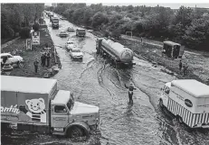  ??  ?? Aus dem Tagesgesch­äft eines Fotojourna­listen: Zäh fließender Verkehr durch eine Überschwem­mung.