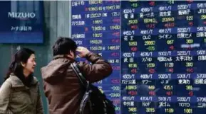  ?? [FOTO AFP] ?? Saham Asia meningkat semalam selepas pelabur menjejaki peningkata­n di Wall Street.