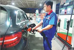  ?? WANG BIAO / FOR CHINA DAILY ?? An attendant refuels a vehicle at a gas station in Fuyang, Anhui province.