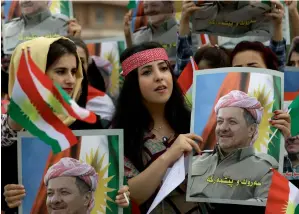  ?? —AFP photos ?? Iraq’s constituti­on gives undue rights to regional government­s. The unpleasant implicatio­ns were particular­ly visible in Kurdistan recently. Above, students holding posters of Massud Barzani. Below, Iraqi troops participat­ing in a ceremony at the...