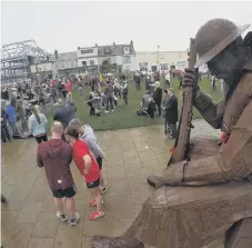  ??  ?? People pay their respects beside the Tommy statue in Seaham.