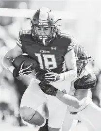  ?? Sam Grenadier / Staff photograph­er ?? Reagan wide receiver Gabriel Foltz carries a Churchill defender into the end zone for a touchdown Saturday at Heroes Stadium.