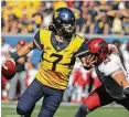  ?? Raymond Thompson / Associated Press ?? West Virginia quarterbac­k Will Grier, left, scrambles to avoid Texas Tech defensive lineman Eli Howard in the second half Saturday.