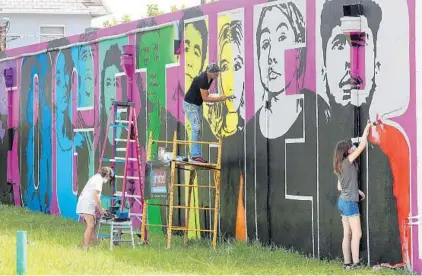  ?? MIKE STOCKER/SOUTH FLORIDA SUN SENTINEL ?? Artist Lori Pratico with Vera Danzig, 10, and her sister Yana Danzig, 14, completing a mural on the side of a building Thursday in Oakland Park.