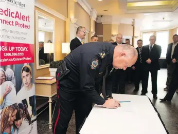  ?? TROY FLEECE ?? Regina police Chief Evan Bray signs a partnershi­p between the Saskatchew­an Associatio­n of Chiefs of Police and the Canadian Medicalert Foundation that will help officers locate lost or missing people.