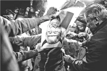  ??  ?? Indian Hindu activists burn an effigy of Chief Minister of Kerala Pinarayi Vijayan during a demonstrat­ion over two women entering the Sabarimala Ayyapa temple in the southern state of Kerala, in New Delhi. — AFP photo