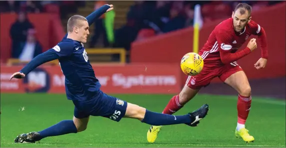  ??  ?? Kilmarnock’s Iain Wilson challenges Niall McGinn for the ball during his side’s 3-0 defeat to Aberdeen at Pittodrie