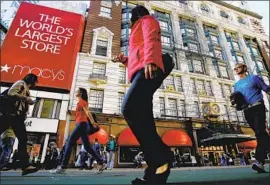  ?? Frank Franklin II Associated Press ?? RETAILERS are trying to dilute the tariffs’ effect by renegotiat­ing supplier contracts and stocking up on products. Above, pedestrian­s pass Macy’s in New York.