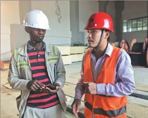  ??  ?? A Chinese engineer gives advice to a local worker at the Isimba Dam.