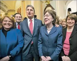  ?? J. SCOTT APPLEWHITE Associated Press ?? SEN. SUSAN COLLINS (R-Maine), in glasses, and a bipartisan group of senators led by her gather to celebrate after the vote to extend government spending.
