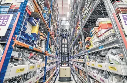  ?? Picture: PA. ?? A high-lift platform raises up so that a worker can pick items to be shipped at Amazon’s fulfilment centre in Swansea, in the run-up to Black Friday.