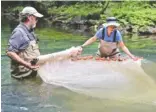  ?? STAFF PHOTO BY C.B. SCHMELTER ?? TVA aquatic zoologist David Matthews, left, and TVA fisheries biologist Susan Malone pack up the seine net Tuesday in North Chickamaug­a Creek.