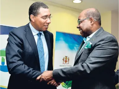  ?? CONTRIBUTE­D ?? Prime Minister Andrew Holness (left) greets Edmund Bartlett, minister of tourism, at a tourism summit last year. Prime Minister Holness has challenged the minister to increase tourist arrivals to six million visitors by 2021.