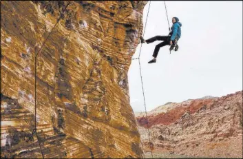  ??  ?? Eric Wesseling of Cincinnati figures out his next holds while climbing at Calico Basin during Red Rock Rendezvous on Saturday.