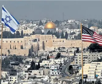  ?? AHMAD GHARABLI/GETTY IMAGES ?? The Israeli and U.S. flags placed on the roof of an Israeli settlement building in East Jerusalem and Jerusalem’s Old City with the Dome of the Rock mosque in the centre on Wednesday.