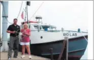  ?? COURTESY — BILL CUTCHER ?? Tammy Perry, left, and Matt Thomas in front of a boat built by Perry’s grandparen­ts in Vermilion in 1947. The boat is now owned by the state of Ohio