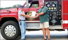  ?? MEGAN DAVIS/MCDONALD COUNTY PRESS ?? Assistant Fire Chief Richard Huston accepts a grant check in the amount of $1,187.50 from Kevin Chew, with the Missouri Department of Conservati­on. Tiff City Fire Department used the money to help fund the purchase of two 5,000 gallon water storage...